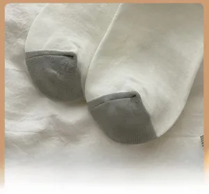 Détail de la pointe renforcée sur des chaussettes blanc et gris avec motif d'ours
