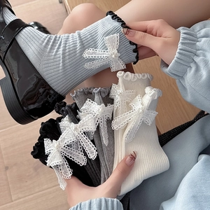 Women's crew socks with ruffled cuffs, pearl bow accents, and ribbed cotton texture