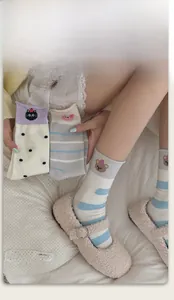 Detail of high-elastic ribbed cuff on colorful striped socks with cute animal embroidery