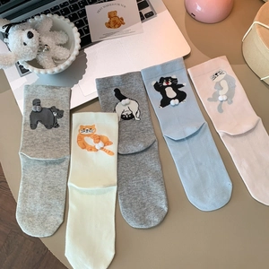 Five pairs of cute cartoon cat cotton mid-tube socks with 3D pom-poms on cozy desk