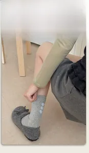 Detail of grey calf-length socks with blue heart embroidery and elastic ribbed cuffs