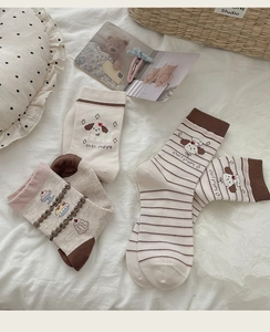 Detailed set of cute embroidered puppy socks in cream and brown with soft cotton texture