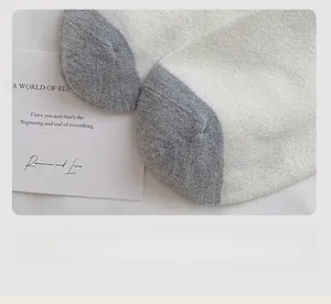 Detailed macro view of seamless toe stitching on white and grey wool blend socks