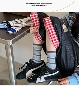 Dettaglio di calze a righe in cotone multicolore mostrate con oggetti lifestyle casual