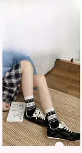 Détail de chaussettes d'hiver en tricot avec motifs de pingouins et flocons blancs sur noir