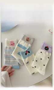 Close-up of four pairs of cotton socks featuring animal embroidery and striped patterns
