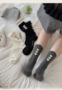 Detailed knit of grey mid-calf socks with heart pattern accents and ribbed cotton texture