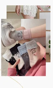 Detail of ruffled cuff socks featuring cute cartoon puppy patterns in various colors
