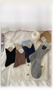 Close-up of cotton crew socks featuring cute animal embroidery and ribbed cuff details