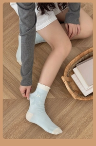 Détail de chaussettes en coton bleu clair avec motif ours et bordure en dentelle blanche