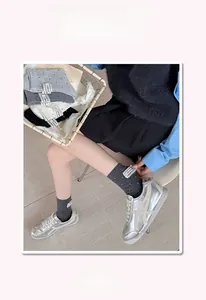 Detail of high-stretch cotton mid-tube socks featuring lace labels and pearl embellishments