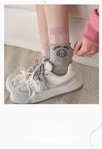 Detail of pink and grey cotton socks with cute cartoon puppy and ruffled edges