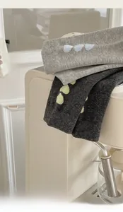 Detail of grey cotton mid-calf socks with heart embroidery in light and dark charcoal hues