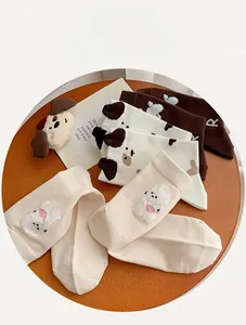 Vue à plat de chaussettes en coton avec écussons de chiens et motifs imprimé vache