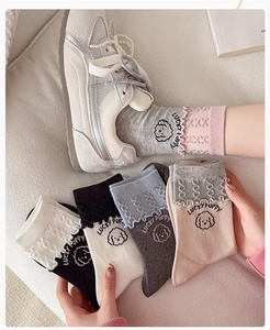 Detail of ruffle cuff cotton socks with Lucky Puppy cartoon prints and colorful patterns