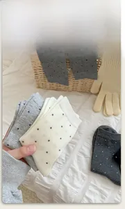 Detailed texture of cotton crew socks with colorful polka dots in neutral grey and beige