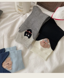 Detail of cartoon animal embroidery on colorful cotton crew socks in neutral tones