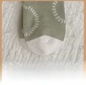 Detail view of cotton knitted socks with green and white color block and circle pattern