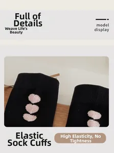 Detail of high-elasticity ribbed cuff on black crew socks featuring pink heart pattern
