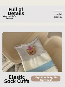 Close-up of elastic ribbed cuff on striped cotton socks featuring cute bear embroidery