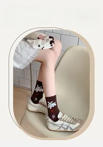 Détail de chaussettes en maille marron avec motif chiot blanc et petit cœur rouge vif