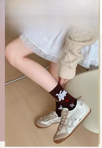 Détail de chaussettes marron en coton avec broderie mignonne de chiot et cœur