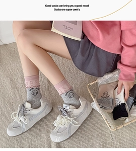 Detailed close-up of cute cartoon puppy print and pink ruffle cuff on cotton crew socks