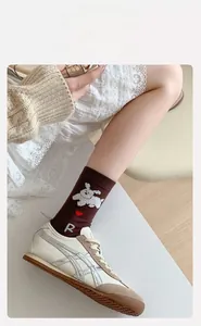 Détail de chaussettes marron avec motif de chien de dessin animé et revers côtelés