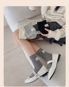 Detail of polka dot crew socks with lace 'NICE MOMENT' patch and frilled cuffs