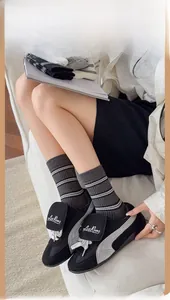 Detail of grey striped crew socks paired with modern black and grey sneakers