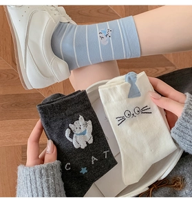 Close-up of cute cat pattern socks in striped and solid colors with knit texture