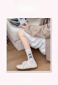 Détail de chaussettes mi-mollet blanches avec motif yeux XX et bords-côtes confort