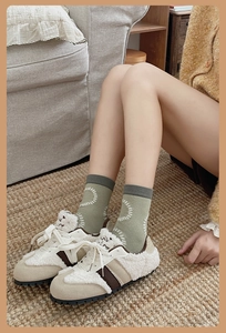 Detail of olive green crew socks with white circles paired with beige fleece lined shoes