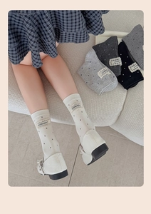 Detail of polka dot crew socks with delicate lace trim and letters woven label