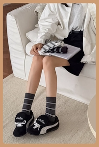 Detail of grey, black and white striped cotton crew socks with ribbed cuffs shown in lifestyle
