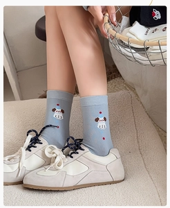 Close-up of light blue cotton socks with cartoon dog embroidery and ribbed cuffs