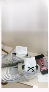 Détail de chaussettes en tricot blanc avec nœuds noirs et chaussures Mary Jane argentées