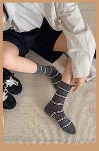 Detail of grey ribbed cotton socks with white stripes shown on feet for realistic fit