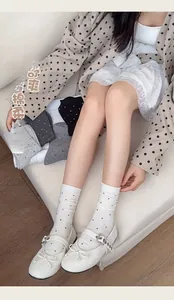 Detail view of gray and white polka dot cotton crew socks with a soft knit texture