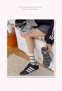 Close-up of striped cotton crew socks with elastic ribbed cuffs and logo patch