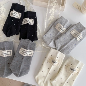 Set of four mid-calf socks with polka dots and lace labels in black, grey, and cream