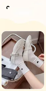Close-up of white cotton socks with black heart embroidery and Mary Jane shoes