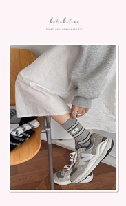 Detailed view of grey striped crew socks with egg label in a cozy home setting