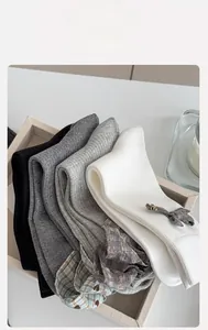 Detailed view of grey and white rib-knit socks with lace trim and patterns in a tray