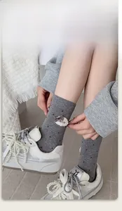 Detail of grey polka dot socks with plush cloud and bow plus pearl laced sneakers