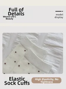 Detail showing elastic ribbed cuff and brown polka dots on off-white cotton socks