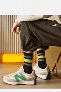 Close-up of men's striped black athletic socks paired with retro sneakers and cargo pants