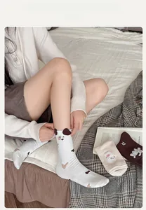 Gros plan de chaussettes dalmatien avec oreilles 3D et broderie ours sur lit