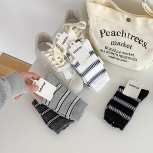 Set of minimalist striped crew socks in white, grey, and black with soft cotton texture
