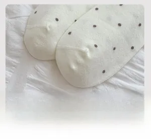 Detailed close-up showing flat toe seam and fine knit texture of polka dot socks